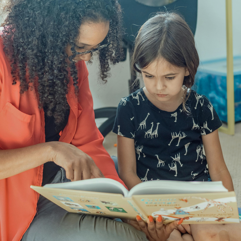 Une professionnelle de santé montre un livre à une enfant malade.